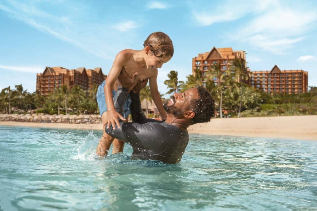 Family relaxing on vacation at Aulani, A Disney Resort & Spa